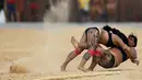 Dua wanita adat sedang bergulat dalam pertandingan yang disebut Huka Huka pada Olimpiade bagi Masyarakat adat, Palmas, Brasil, (30/10/2015). Sekitar 48 etnik yang akan terdiri atas empat ribu atlet ikut dalam Olimpiade ini. (REUTERS/Ueslei Marcelino)