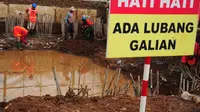 Sebuah papan peringatan terpasang di proyek sodetan Kali Ciliwung di kawasan Otista, Jakarta, Kamis (10/7/14). (Liputan6.com/Faizal Fanani)