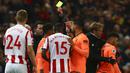 Wasit memberikan karu kuning kepada gelandang Liverpool, Alex Oxlade-Chamberlain dan bek Stoke, Bruno Martins Indi pada laga Premier League di Stadion Bet365, Stoke-on-Trent, Rabu (29/11/2017). Stoke kalah 0-3 dari Liverpool. (AFP/Geoff Caddick)