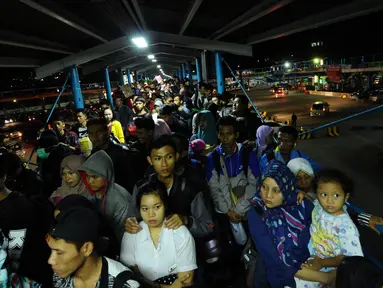 Sejumlah pemudik menanti waktu masuk ke dalam kapal penyeberangan di Dermaga I Pelabuhan Merak, Banten, Kamis (22/6). Dini hari, ribuan pemudik menyeberang dari Pelabuhan Merak menuju Bakauheni, Lampung. (Liputan6.com/Helmi Fithriansyah)