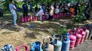 Di sisi lain, PT Pertamina (Persero) menyatakan telah menggunakan semua moda transportasi darat, udara, dan laut untuk memastikan distribusi energi, termasuk gas elpiji berjalan lancer. Tampak dalam foto, warga menunggu untuk membeli tabung gas di sebuah stasiun pengisian dan pembelian LPG setelah banjir bandang di Banda Aceh pada Rabu 17 Desember 2025. (CHAIDEER MAHYUDDIN/AFP)