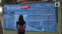 Orang tua murid mencari informasi pengajuan akun untuk mengikuti proses penerimaan Peserta Didik Baru (PPDB) Tahun Pelajaran 2021/2022 di SMA Negeri 87 Jakarta, Senin (7/6/2021).  (Liputan6.com/Herman Zakharia)