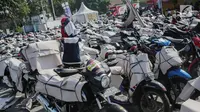 Pekerja membungkus motor pemudik sebelum dikirim dengan kereta api di Stasiun Jakarta Gudang, Selasa (28/5/2019). Direktorat Lalu Lintas dan Angkutan Kereta Api Kementerian Perhubungan mengangkut 18.096 motor pemudik secara gratis pada mudik Lebaran 2019. (Liputan6.com/Faizal Fanani)