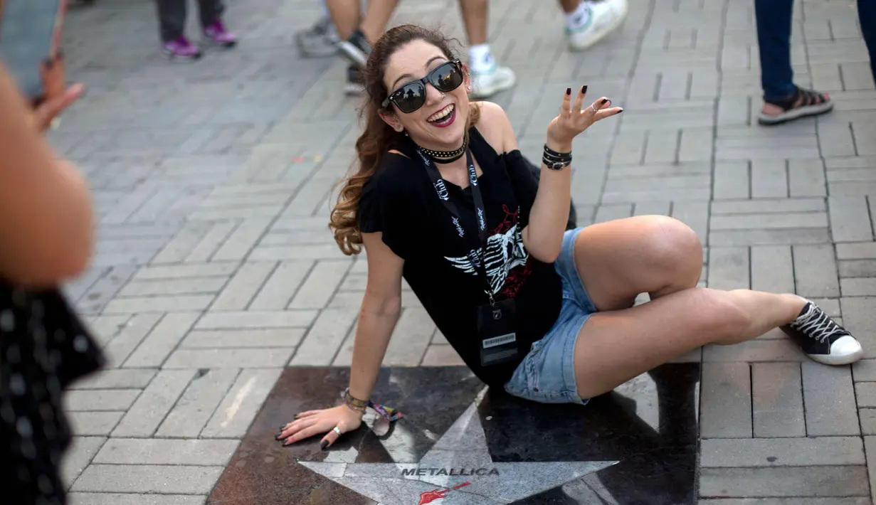 Penonton wanita berselfie di samping bintang Metallica saat menghadiri Rock in Rio Festival di Olympic Park, Rio de Janeiro, Brazil, (21/9). Festival ini berlangsung  selama tujuh hari 15-17 September dan 21-24. (AFP Photo/Mauro Pimentel)