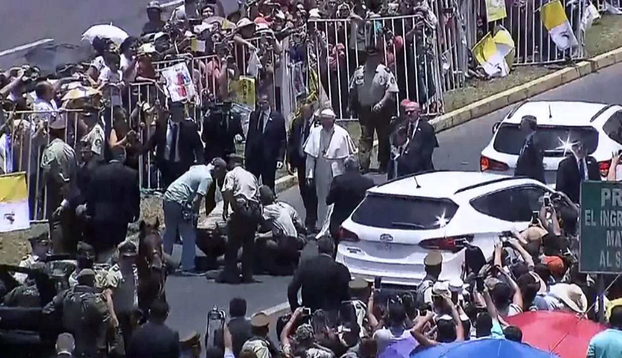 Paus Fransiskus menghampiri polisi perempuan yang terjatuh dari kudanya saat rombongan Pemimpin Gereja Katolik Roma itu melewati umat di jalanan kota Iquique, Chile, Kamis (18/1). (HO/NATIONAL COMMISSION FOR THE POPE’S VISIT AND CHILEAN CHANNELS/AFP)