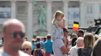 Seorang anak kecil memegang bendera nasional ketika melihat parade selama perayaan Hari Nasional Belgia di Brussels, Kamis (21/7). Belgia dalam status waspada sejak tragedi Bom Brussels yang menewaskan 34 orang pada 22 Maret 2016 lalu. (Foto: Arie Asona)