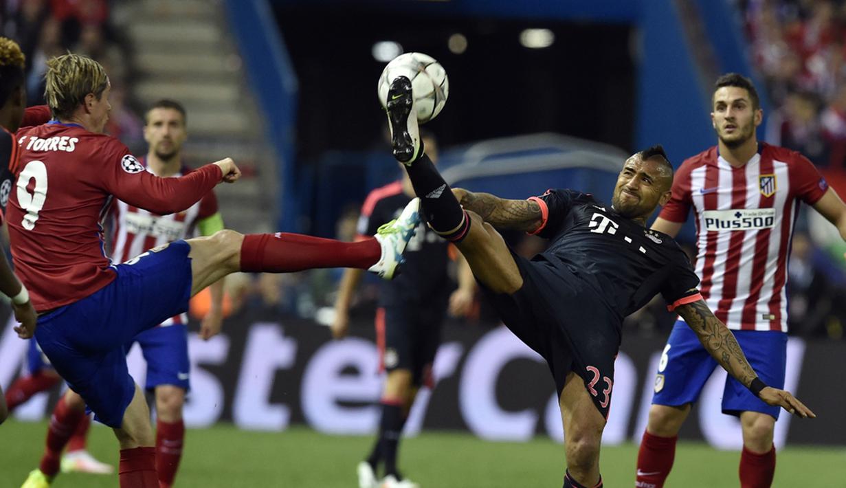 Striker Atletico Madrid, Fernando Torres, berebut bola dengan pemain Bayern Munchen, Arturo Vidal, pada leg pertama semifinal Liga Champions di Stadion Vicente Calderon, Madrid, Kamis (28/4/2016) dini hari WIB. (AFP/Gerard Julien) 