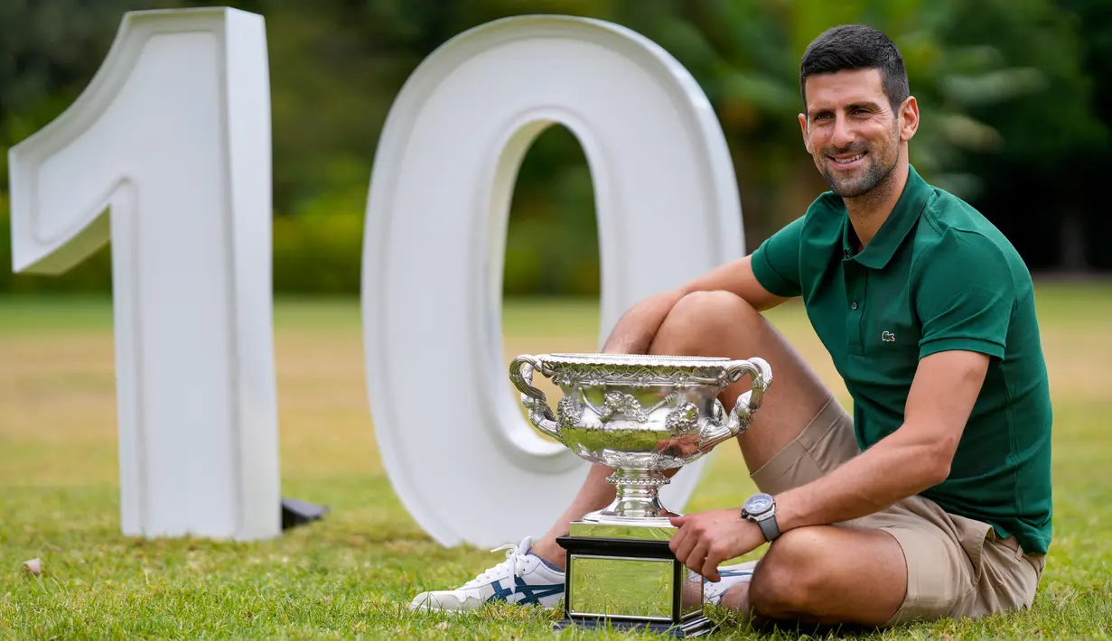 Petenis Serbia Novak Djokovic berpose dengan Norman Brookes Challenge Cup usai menjuarai Australian Open 2023 di Taman Government House, Melbourne, Australia, 30 Januari 2023. Pencapaian ini membuat petenis berusia 35 tahun tersebut sekarang menyamai rekor Rafael Nadal dari Spanyol dengan total 22 gelar grand slam. (AP Photo/Ng Han Guan)
