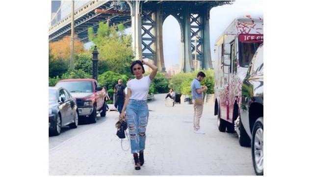Yuni Shara memakai ripped jeans dan atasan kaos putih, simple dan keren.