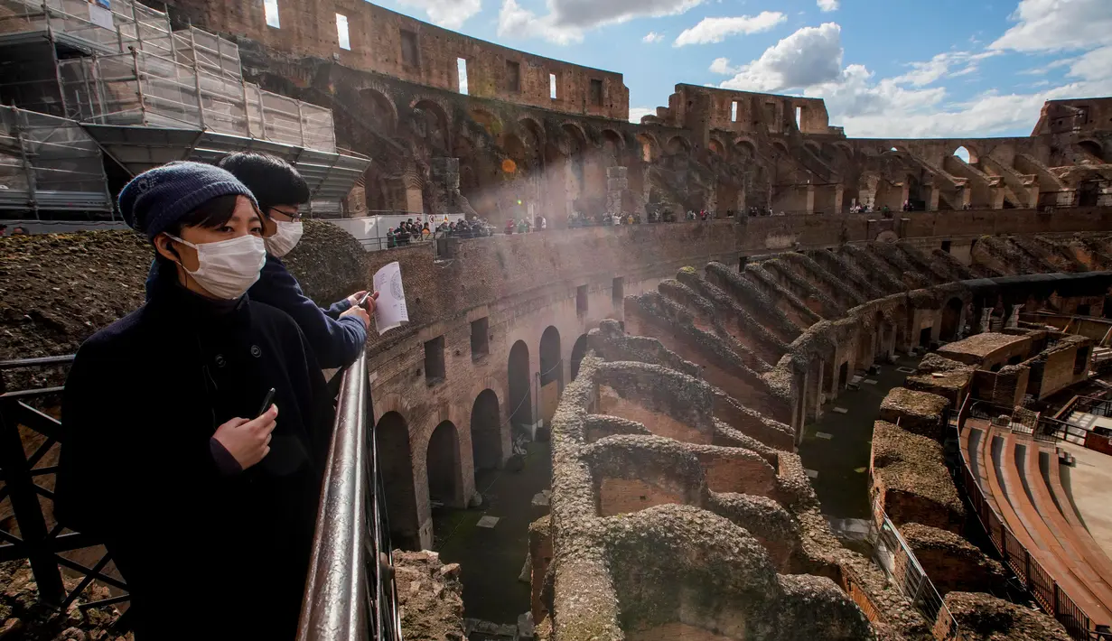 Wisatawan mengunjungi Colosseum di Roma, Sabtu (7/3/2020). Kekhwatiran terhadap virus corona (COVID-19) membuat tempat-tempat pariwisata di Italia sepi pengunjung, seperti di kawasan Colosseum yang merupakan salah satu dari keajaiban dunia. (AP Photo/Andrew Medichini)