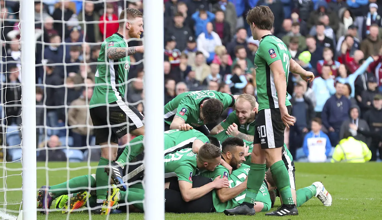 Para pemain Lincoln City FC merayakan gol Sean Raggett saat melawan Burnely pada babak kelima Piala FA di Turf Moor, Sabtu (18/2/2017), dan mengantarkan mereka ke perempat-final, Lincoln City menang 1-0. (Martin Rickett/PA via AP)