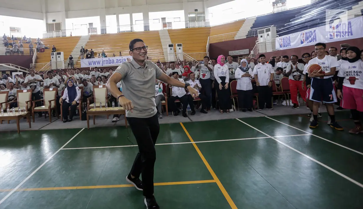 Gaya Wakil Gubernur DKI Jakarta Sandiaga Salahudin Uno usai menembakan bola ke dalam ring dalam pembukaan pelatihan pendidikan Basket di Gor Ciracas, Jakarta, Rabu (24/1). (Liputan6.com/Faizal Fanani)