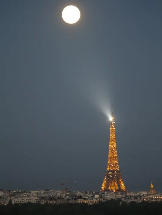 Fenomena alam Supermoon tampak di atas menara Eiffel yang terlihat dari Suresnes, Perancis, Minggu (27/9). Gerhana Bulan Supermoon (Bulan merah darah) kembali menampakkan keindahannya setelah 18 tahun tidak terjadi. (REUTERS/Charles Platiau)