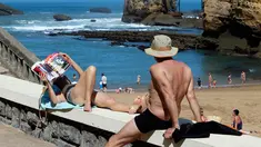 Seorang wanita membaca majalah saat berjemur di pantai Port Vieux, (Old Seaport) di Biarritz, barat daya Prancis, (19/4). Suhu di Prancis barat daya telah mencapai 27 derajat Celcius (80,6 Fahrenheit). (AP Photo / Bob Edme)