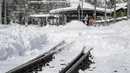 Kondisi rel kereta api yang tertutup salju tebal di desa Taesch, Pegunungan Alpen Swiss, (10/1). Pemadaman listrik di beberapa daerah lain, seperti di Kota Valais, juga terjadi akibat hujan salju lebat. (AFP Photo/Fabrice Coffrini)