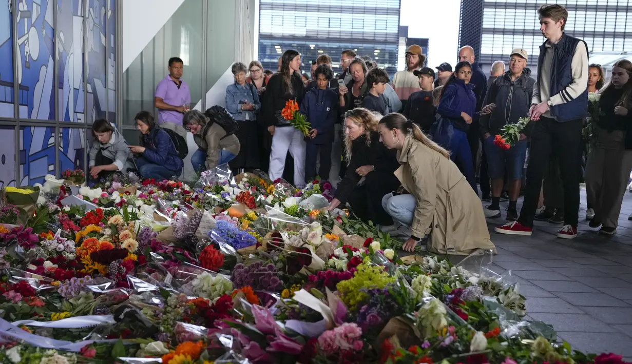 Orang-orang meletakkan bunga untuk mengenang para korban pada pintu masuk pusat perbelanjaan Field di Kopenhagen, Denmark, 5 Juli 2022. Polisi mengesampingkan bahwa serangan hari Minggu itu terkait dengan terorisme. (AP Photo/Sergei Grits)
