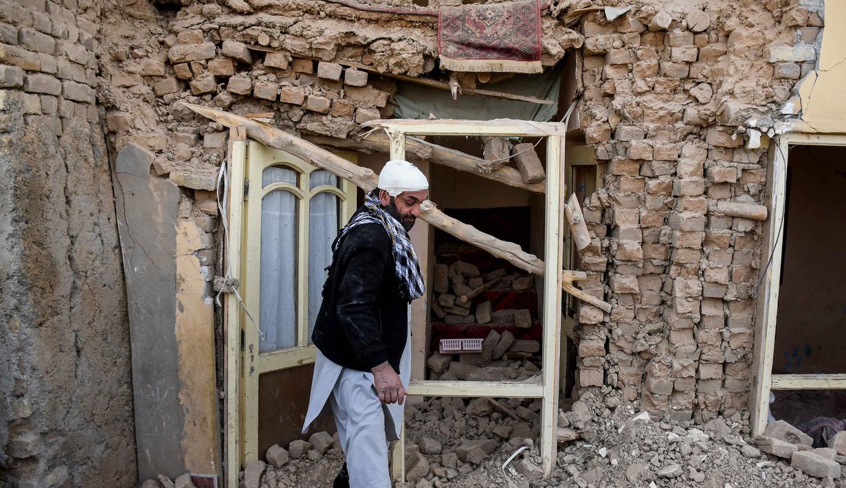 Seorang penyintas gempa bumi Afghanistan berjalan melewati reruntuhan rumah yang rusak di sebuah desa di Tashqurghan, distrik Khulm, provinsi Samangan, pada Senin 3 November 2025. Jumlah korban diperkirakan akan terus bertambah seiring berlanjutnya upaya penyelamatan. (Atif Aryan/AFP)