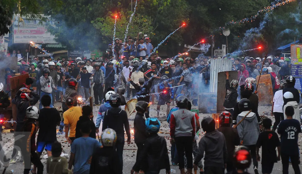 Tawuran antarwarga kembali pecah di dekat Stasiun Manggarai, Jakarta Selatan, Minggu (8/1). Puluhan orang terlihat membawa senjata tajam, bongkahan batu dan petasan. (Liputan6.com/Angga Yuniar)