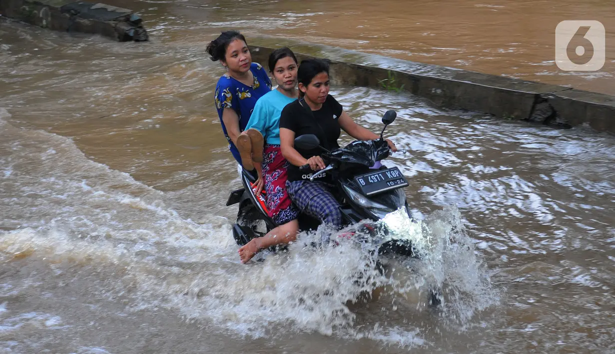 Pengendara motor melintasi banjir di Jalan Benteng,  Duta Kranji, Kalibaru, Bekasi, Jawa Barat, Jumat (24/2/2023). Jalan yang dilalui oleh para pengendara masih digenangi air ditambah dari luapan kalibaru Duta Kranji akibat hujan deras yang mengguyur Kota Bekasi sejak Kamis (23/2/2023) malam. (merdeka.com/Imam Buhori)