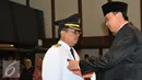 Basuki T Purnama (kanan ) memberikan tanda pangkat ke Wakil Walikota Jaksel Tri Kurniadi (kiri) pada saat pelantikan di balai kota, Jakarta, Kamis (13/8/2015). Tri resmi menggantikan Syamsuddin Noor yang dipecat. (Liputan6.com/Herman Zakharia)