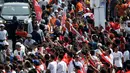 Warga menyambut kedatangan obor saat prosesi Torch Relay Asian Games 2018 di Jalan Jendral Sudirman, Jakarta, Sabtu (18/8). Hari terakhir kirab obor Asian Games ini api abadi dibawa dari Tugu Monas hingga Gelora Bung Karno. (Liputan6.com/ Fery Pradolo)