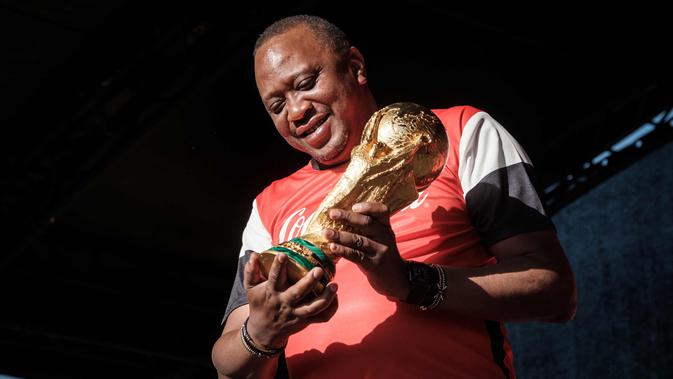 Presiden Kenya Uhuru Kenyatta memegang trofi Piala Dunia FIFA saat Tur Dunia di Gedung Negara, Nairobi (26/2). Trofi ini terbuat dari emas murni 18 karat dengan dasar perunggu, setinggi 36,8 sentimeter dan berat 6,1 kilogram. (AFP Photo/Yasuyoshi Chiba)