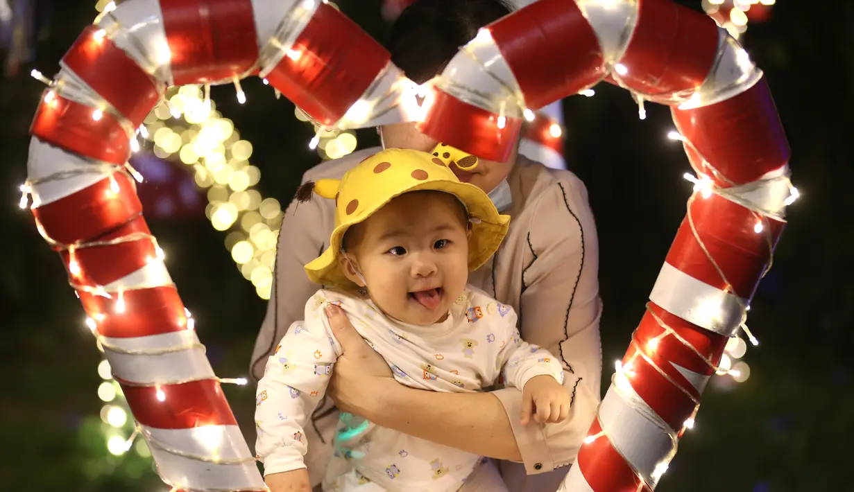 Balita berpose untuk berfoto dengan dekorasi Natal di Yangon, Myanmar(10/12/2020). Berbagai dekorasi hingga akseoris dipasang untuk menyambut Natal di kota tersebut. (Xinhua/U Aung)
