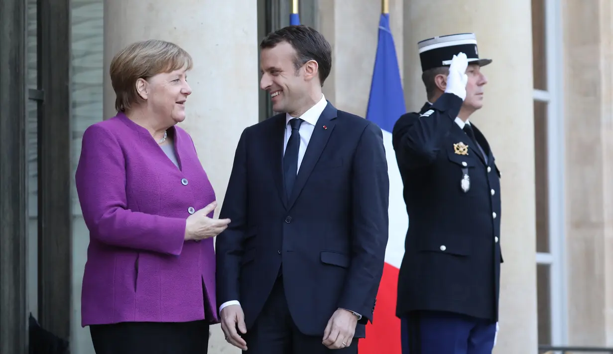 Kanselir Jerman Angela Merkel berbincang dengan Presiden Emmanuel Macron saat kedatangannya di Paris (16/3). Sementara Jerman hingga saat ini bersikap lebih hati-hati, karena Jerman adalah salah satu penyandang dana Uni Eropa. (AFP Photo/Ludovic Marin)