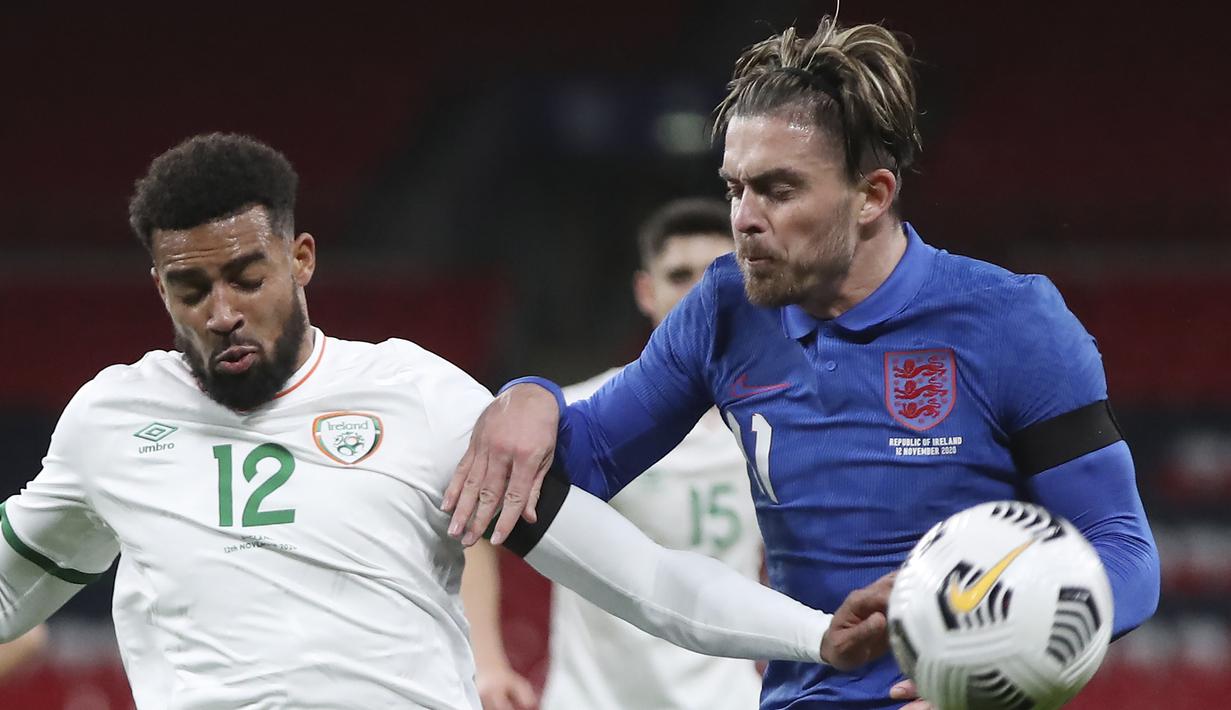 Gelandang Inggris, Jack Grealish (kanan) berebut bola dengan pemain Republik Irlandia, Cyrus Christie, dalam laga uji coba internasional di Stadion Wembley, London, Jumat (13/11/2020) dini hari WIB. Inggris menang 3-0 atas Republik Irlandia. (AP/Nick Potts/Pool)