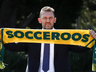 Tony Popovic, pelatih kepala yang baru ditunjuk untuk tim sepak bola nasional Australia, berpose dengan syal setelah konferensi pers di Sydney pada 23 September 2024. (DAVID GRAY/AFP)
