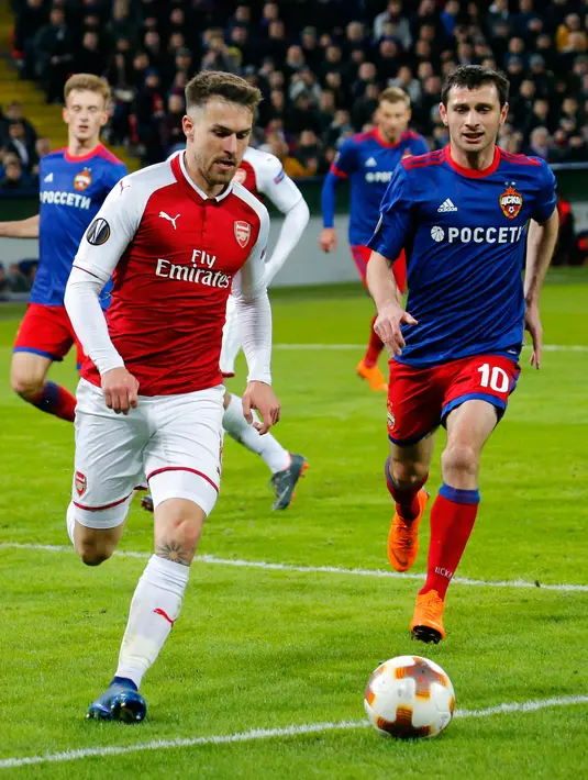 Pemain Arsenal, Aaron Ramsey Kuchaev berebut  bola dengan pemain CSKA Moscow, Alan Dzagoev pada laga leg kedua perempat final Liga Europa di VEB Arena, Jumat (13/4). Pada laga itu, Arsenal hanya mampu bermain imbang dengan skor 2-2. (AP/Pavel Golovkin)