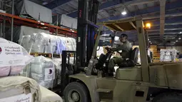 Pengemudi forklift memuat paket bantuan untuk dikirim ke daerah yang terkena gempa di Turki, di Pangkalan Udara Al-Udeid di Doha, Qatar, Selasa, 7 Februari 2023. Gempa bumi dahsyat melanda Turki tenggara dan Suriah Senin dini hari, merobohkan ratusan bangunan serta menewaskan dan melukai ribuan orang. (AP Photo/Kamran Jebreili)