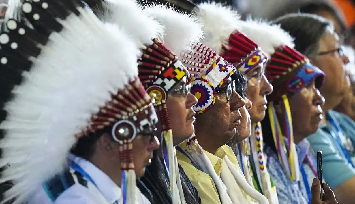 Kepala adat mendengarkan Paus Fransiskus saat perayaan misa di situs ziarah Lac Ste. Anne, Alberta, Kanada, 26 Juli 2022. "Saya minta maaf. Saya meminta pengampunan, khususnya, atas cara-cara di mana banyak anggota Gereja dan komunitas religius bekerja sama, melalui ketidakpedulian mereka, dalam proyek penghancuran budaya dan asimilasi paksa," ungkap Paus Fransiskus. (AP Photo/Eric Gay)