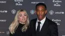 Striker Manchester United, Anthony Martial menggandeng kekasihnya Melanie Da Cruz di karpet merah makan malam acara amal UNICEF di Old Trafford, Rabu (15/11). Event ini sekaligus ajang pamer istri dan kekasih (WAGs) pasukan Red Devils. (Paul ELLIS/AFP)
