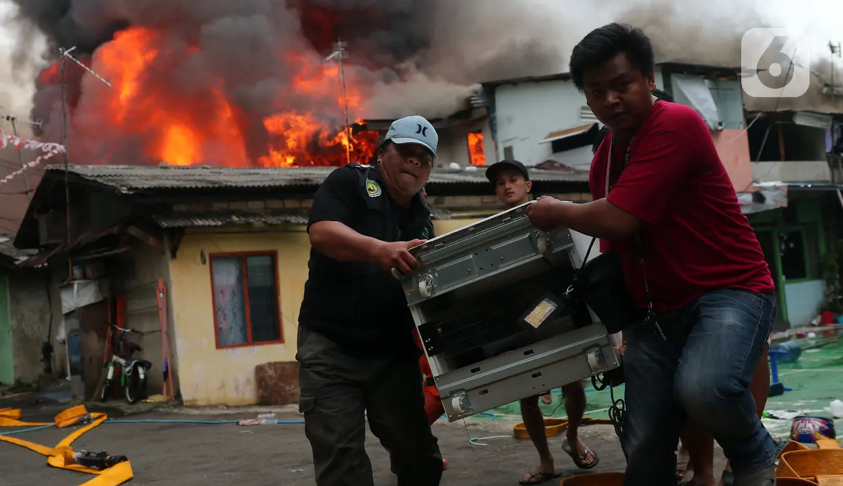 Warga mengevakuasi barang berharga saat terjadi kebakaran di kawasan padat penduduk di Jalan Simprug Golf II RT 4/8, Grogol Selatan, Kebayoran Lama, Jakarta Selatan, Minggu (21/8/2022). Hingga siang ini, petugas pemadam kebakaran bersama warga masih terus berusaha untuk memadamkan api. (Liputan6.com/Angga Yuniar)