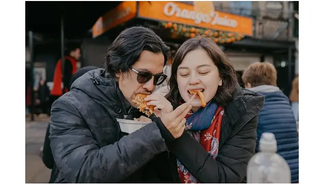 Saat berjalan-jalan di Inggris, keduanya tampil romantis dengan saling suap-suapan.