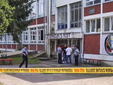 Petugas polisi berdiri di depan gedung sekolah menengah setelah insiden penembakan di Sanski Most, barat laut ibu kota Bosnia, Sarajevo, Rabu (21/8/2024). (AP Photo/Edvin Zulic)