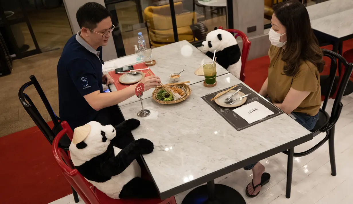 Pelanggan duduk di sebelah boneka panda untuk menjaga jarak di restoran Maison Saigon di Bangkok, Rabu (13/5/2020). Pemerintah Thailand sudah memberlakukan pelonggaran lockdown atau pembatasan wilayah sehingga sejumlah restoran dan toko-toko dapat beroperasi kembali seperti biasa. (AP/Sakchai Lalit)