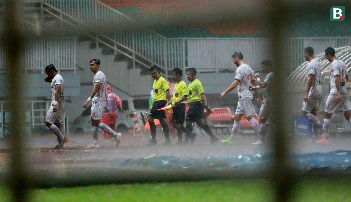 Para pemain Persija Jakarta meninggalkan lapangan usai dihentikannya laga melawan Persiraja Banda Aceh pada menit ke-14 karena hujan deras dalam laga pekan ke-6 BRI Liga 1 2021/2022 di Stadion Pakansari, Bogor, Sabtu (10/2/2021). (Bola.com/M Iqbal Ichsan)