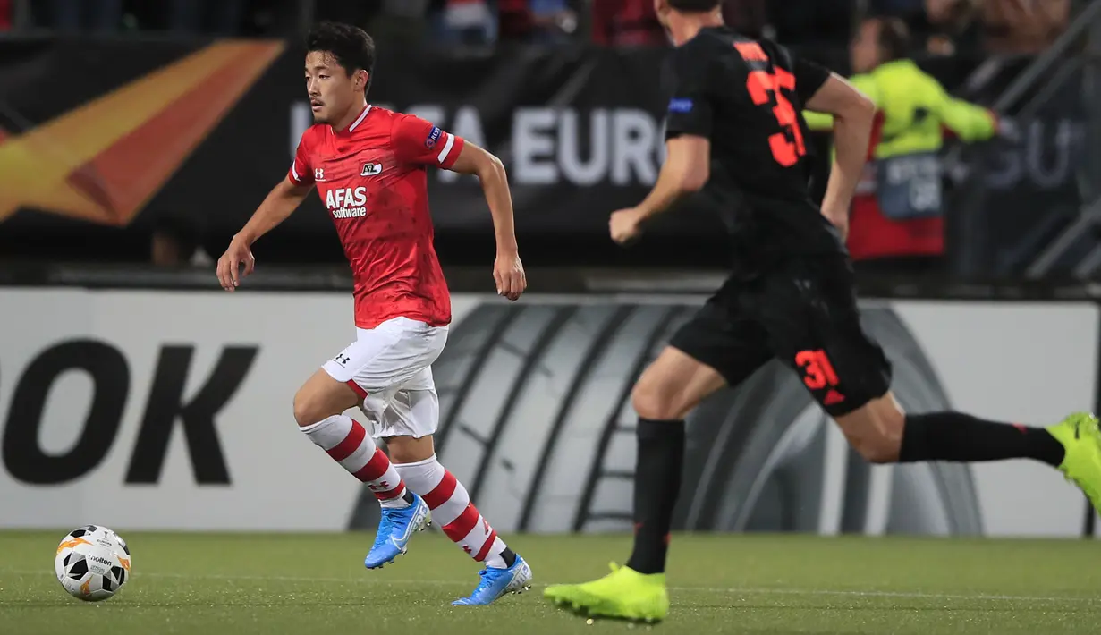 Pemain AZ Alkmaar, Yukinari Sugawara menggiring bola dari kawalan gelandang Manhcester United, Nemanja Matic pada lanjutan pertandingangrup L Liga Europa di stadion ADO Den Haag, Belanda (3/10/2019). MU bermain imbang 0-0 atas AZ Alkmaar. (AP Photo/Peter Dejong)
