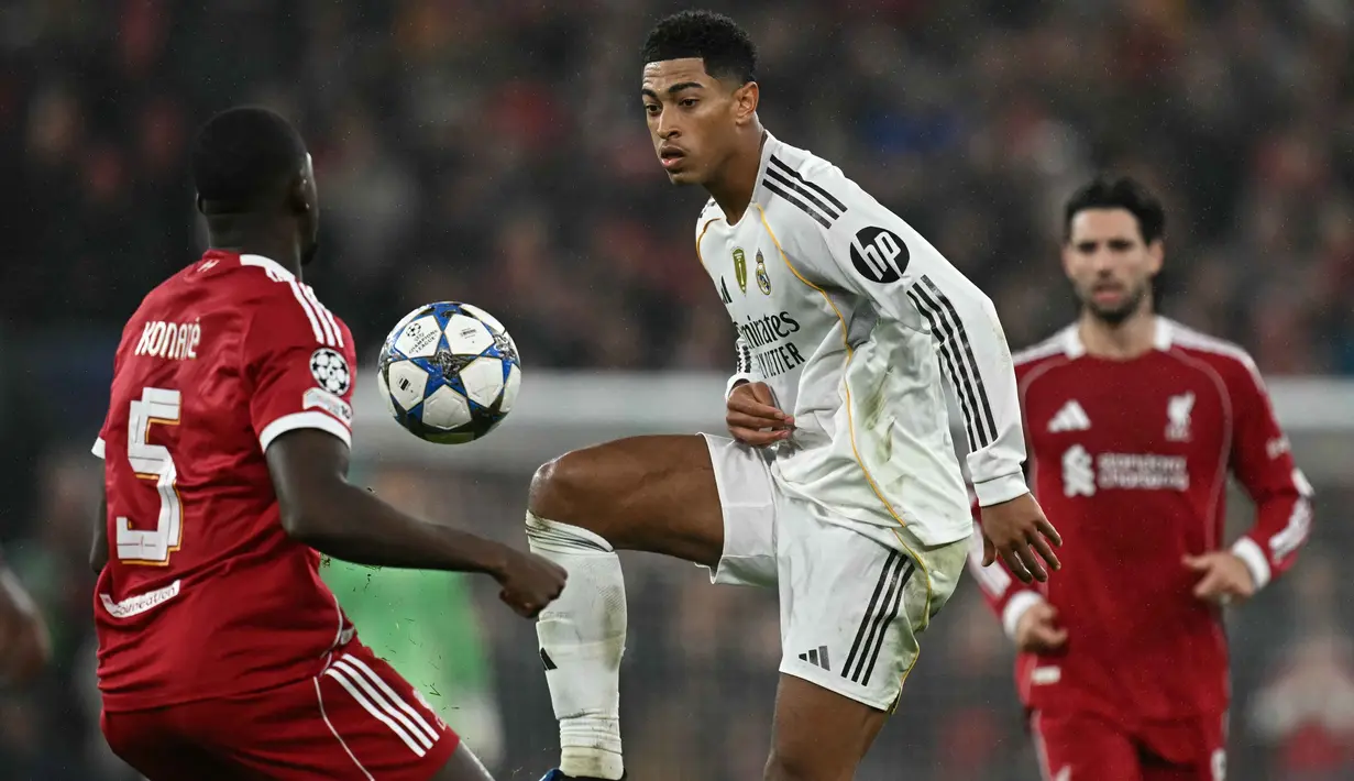 <p>Gelandang Real Madrid asal Inggris, Jude Bellingham (tengah), berebut bola dengan bek Liverpool asal Prancis, Ibrahima Konate (kiri), dalam pertandingan pekan keempat Liga Champions 2025-2026 di Stadion Anfield, Inggris, pada Selasa 4 November 2025 waktu setempat atau Rabu (5/11/2025) dini hari WIB. Dominasi tuan rumah akhirnya berbuah hasil pada menit ke-61. (Paul ELLIS/AFP)</p>