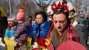 Sepanjang empat tahun, bara perang Rusia-Ukraina tak kunjung padam, korban terus berjatuhan. Tampak dalam foto, seorang wanita mengenakan mahkota bunga saat anggota komunitas Ukraina menggelar protes untuk menandai tahun keempat sejak dimulainya invasi skala penuh Rusia ke Ukraina di Bukares, Rumania, Minggu 22 Februari 2026. (AP Photo/Vadim Ghirda)