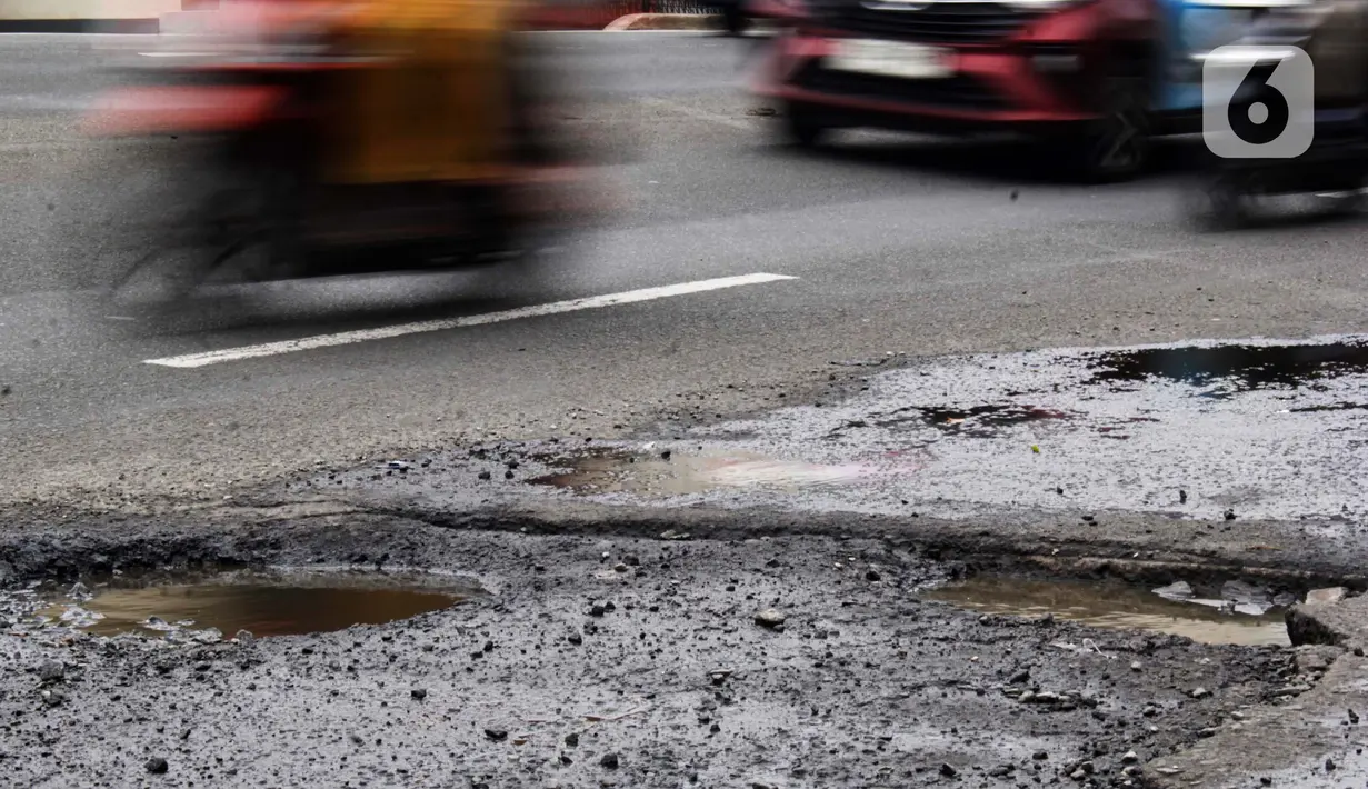 Sejumlah pengendara kendaraan bermotor melewati salah satu titik kerusakan di Jalan Raya Parung-Ciputat Kota Depok, Jawa Barat, Senin (10/2/2025). (Magang/Liputan6.com/Muhammad Rizal)