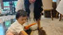 <p>Dalam video singkat, baby Ameena juga sudah mulai memegang kelinci yang dibawa oleh neneknya. Ia juga tampak menyodorkan wortel ditangannya ke kelinci. [Instagram/krisdayantilemos]</p>