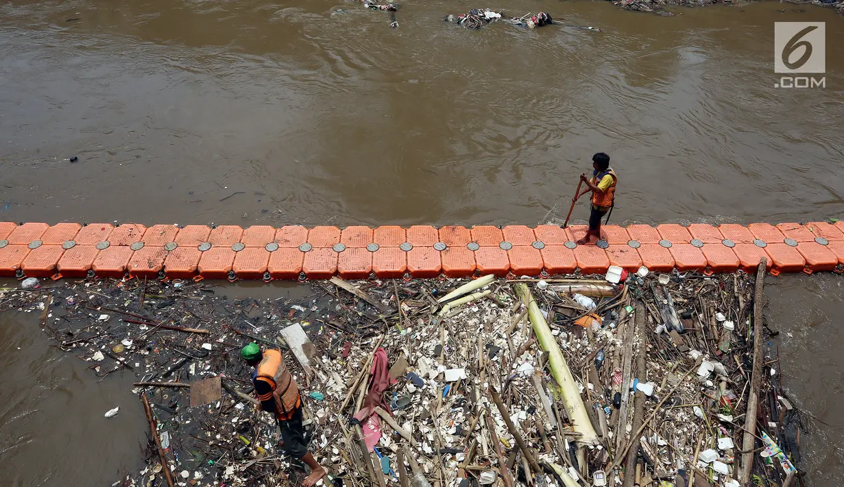 Petugas kebersihan Pemprov DKI mencoba mengurai sampah di Pintu air Manggarai, Jakarta, Senin (2/10). Dinas Kebersihan DKI mengangkat sampah seberat 90-220 ton/hari dari badan air di sungai, waduk, setu dan danau di Ibu Kota. (Liputan6.com/Johan Tallo)