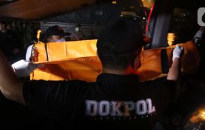 Tim DVI Polri membawa kantong jenazah yang diduga berisi bagian tubuh penumpang pesawat Sriwijaya Air SJ 182 di Dermaga JICT 2, Jakarta, Minggu (10/1/2021) dini hari. Sriwijaya Air SJ 182 hilang kontak empat menit usai lepas landas dari Bandara Soetta. (Liputan6.com/Helmi Fithriansyah)