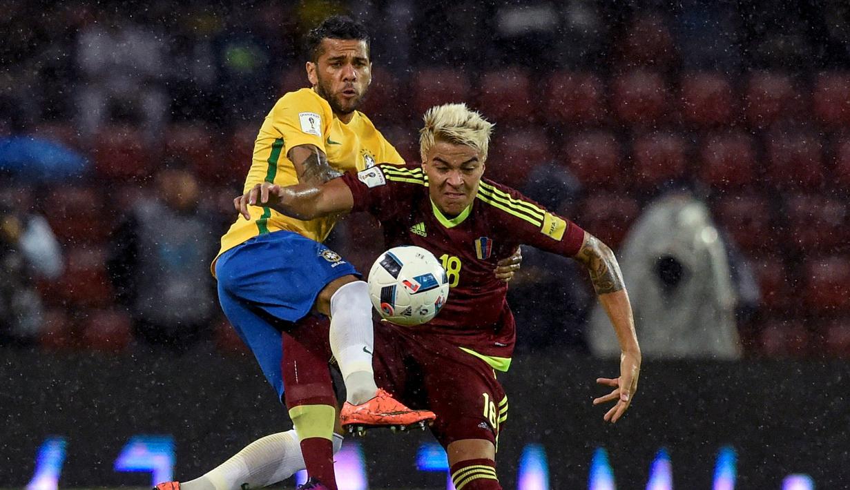 Pemain Brasil, Dani Alves, berebut bola dengan pemain Venezuela, Adalberto Penaranda, dalam laga Kualifikasi Piala Dunia 2018 zona Amerika Selatan di Metropolitano Stadium, Merida, Rabu (12/10/2016) WIB. (AFP/Juan Barreto)