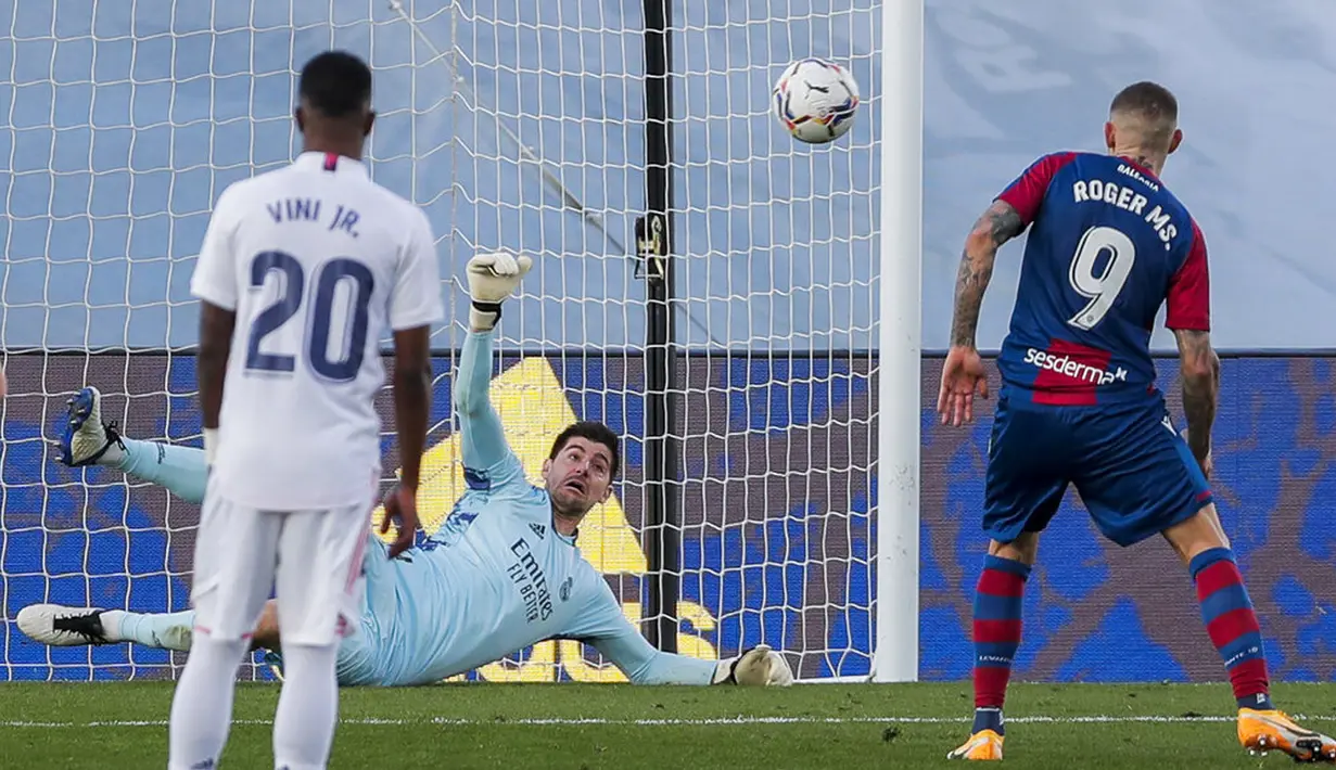Kiper Real Madrid Thibaut Courtois (belakang) menghentikan tendangan penalti dari pemain Levante Roger Marti pada pertandingan Liga Spanyol di Stadion Alfredo Di Stefano, Madrid, Spanyol, Sabtu (30/1/2021). Real Madrid kalah 1-2. (AP Photo/Manu Fernandez)
