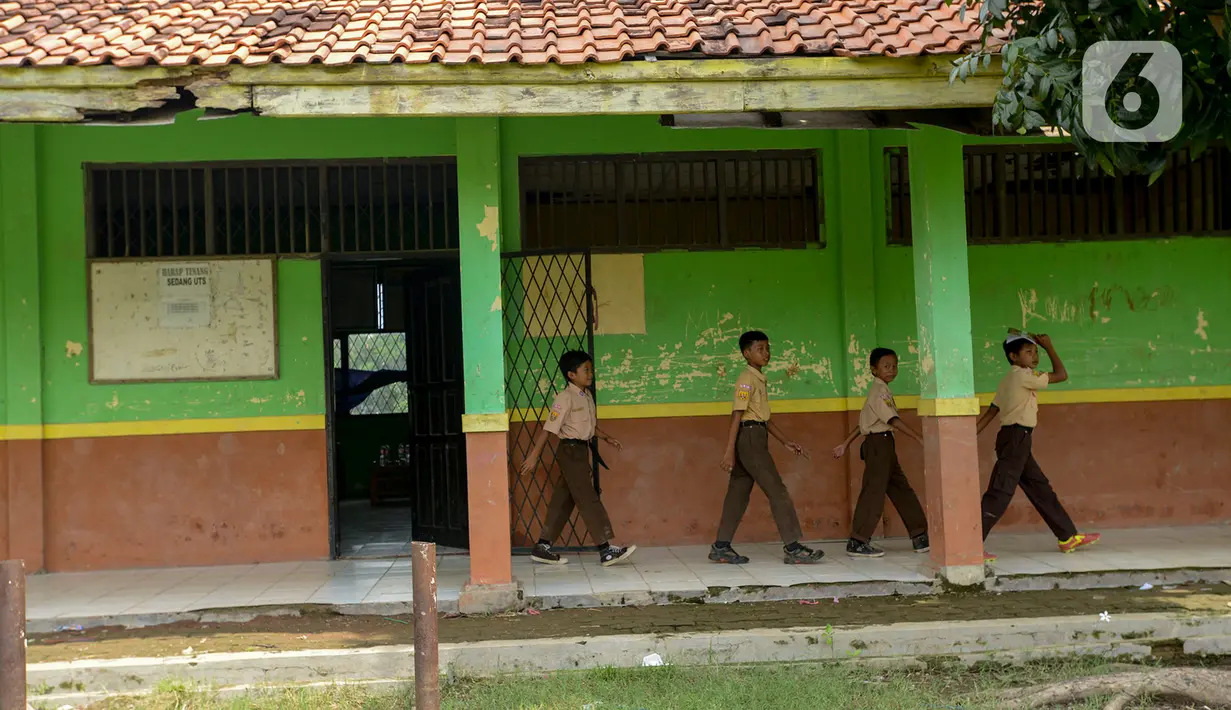 Sejumlah murid berjalan melewati gedung SDN Samudrajaya 04 yang rusak, Desa Samudrajaya, Kecamatan Tarumajaya, Kabupaten Bekasi, Jawa Barat, Selasa (21/1/2020). Murid SDN Samudrajaya 04 terpaksa belajar di gedung sekolah yang rusak sejak tahun 2014. (merdeka.com/Imam Buhori)