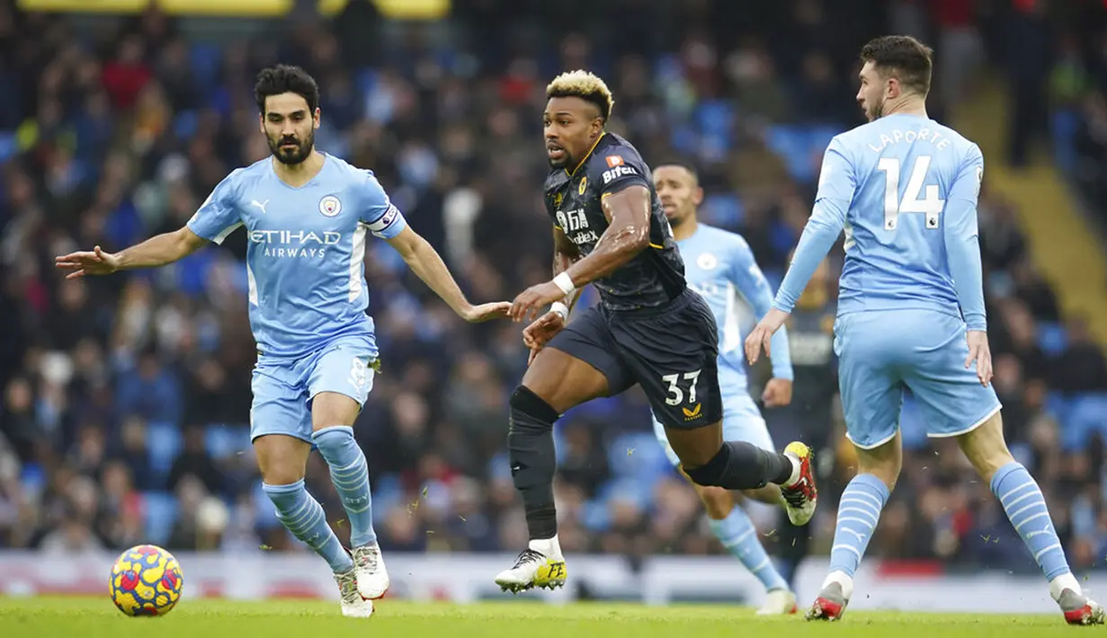 Pemain Wolverhampton Wanderers Adama Traore (tengah) berebut bola dengan pemain Manchester City Ilkay Gundogan (kiri) dan Aymeric Laporte pada pertandingan sepak bola Liga Inggris di Etihad Stadium, Manchester, Inggris, 11 Desember 2021. Manchester City menang 1-0. (AP Photo/Dave Thompson)